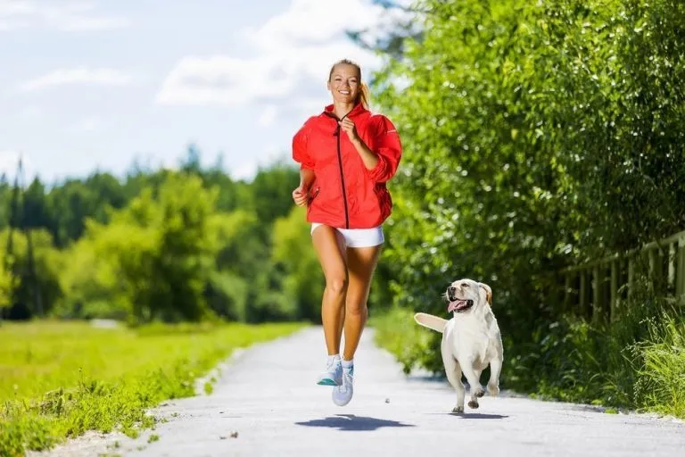 a woman jogging with her dog