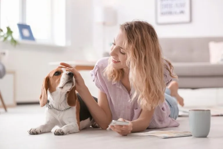a woman lying on the floor stroking a dog